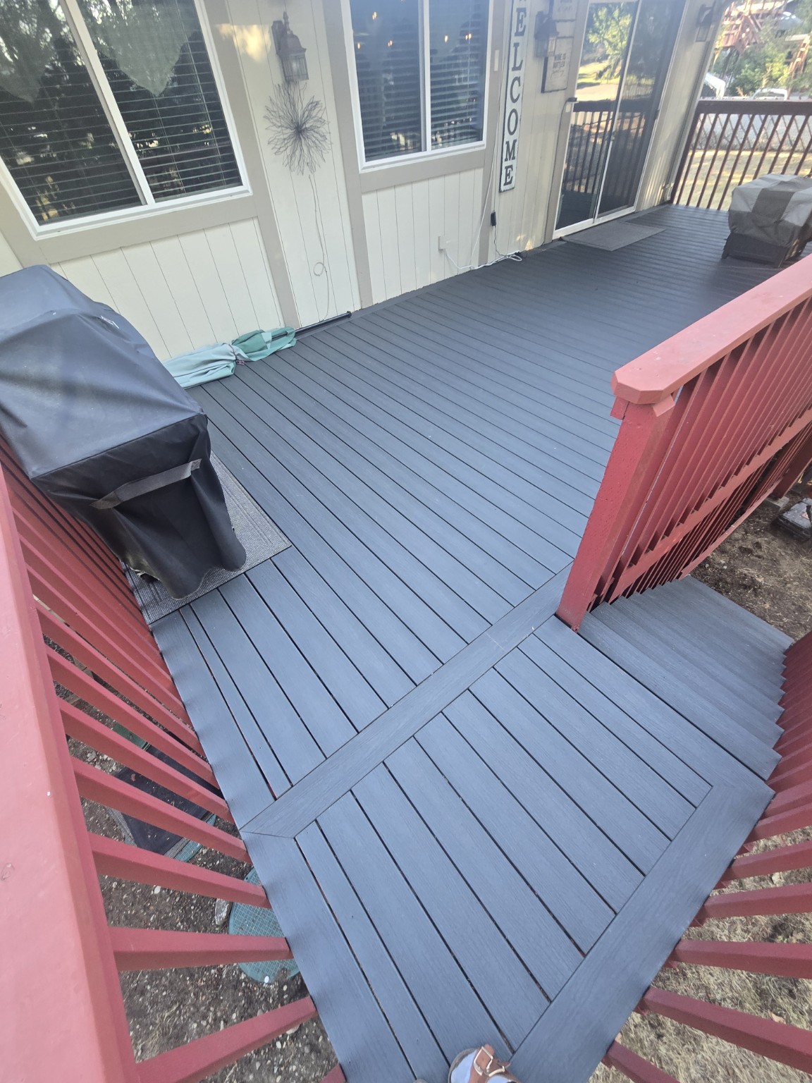 Completed gray Trex deck with picture-frame border and red railing
